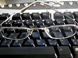 A pair of glasses sitting on a computer keyboard.