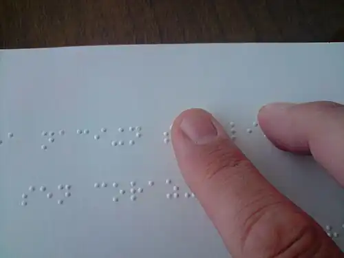 A braille book being read.