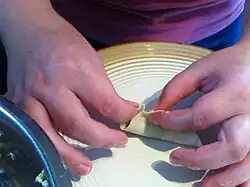 Step 5: Pinch one side of the wrapper into small folds, working down both sides, until a familiar pot sticker shape results.