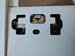 The mechanism for final drawer front adjustment; it can be worked with a Philips screwdriver.