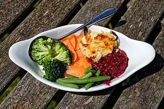 Sunday roast food medley, including steamed runner beans, carrots, brocolli, cauliflower cheese, and a preserve jam